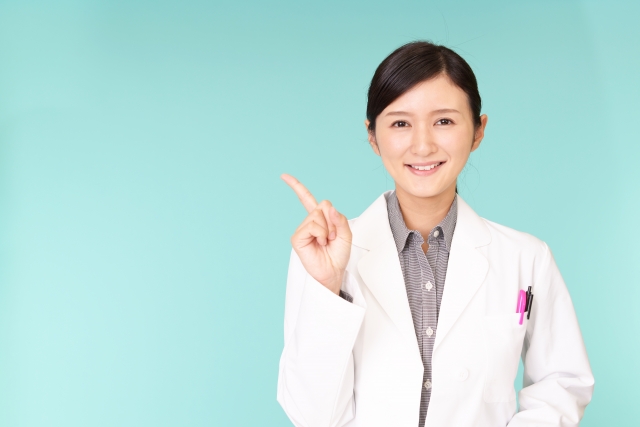 指差しする白衣の女性